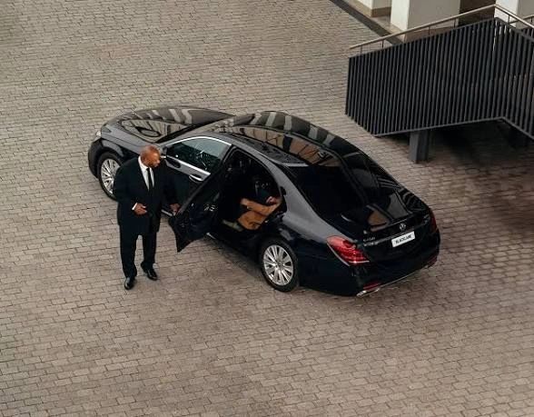 Aerial view businessman beside luxury sedan